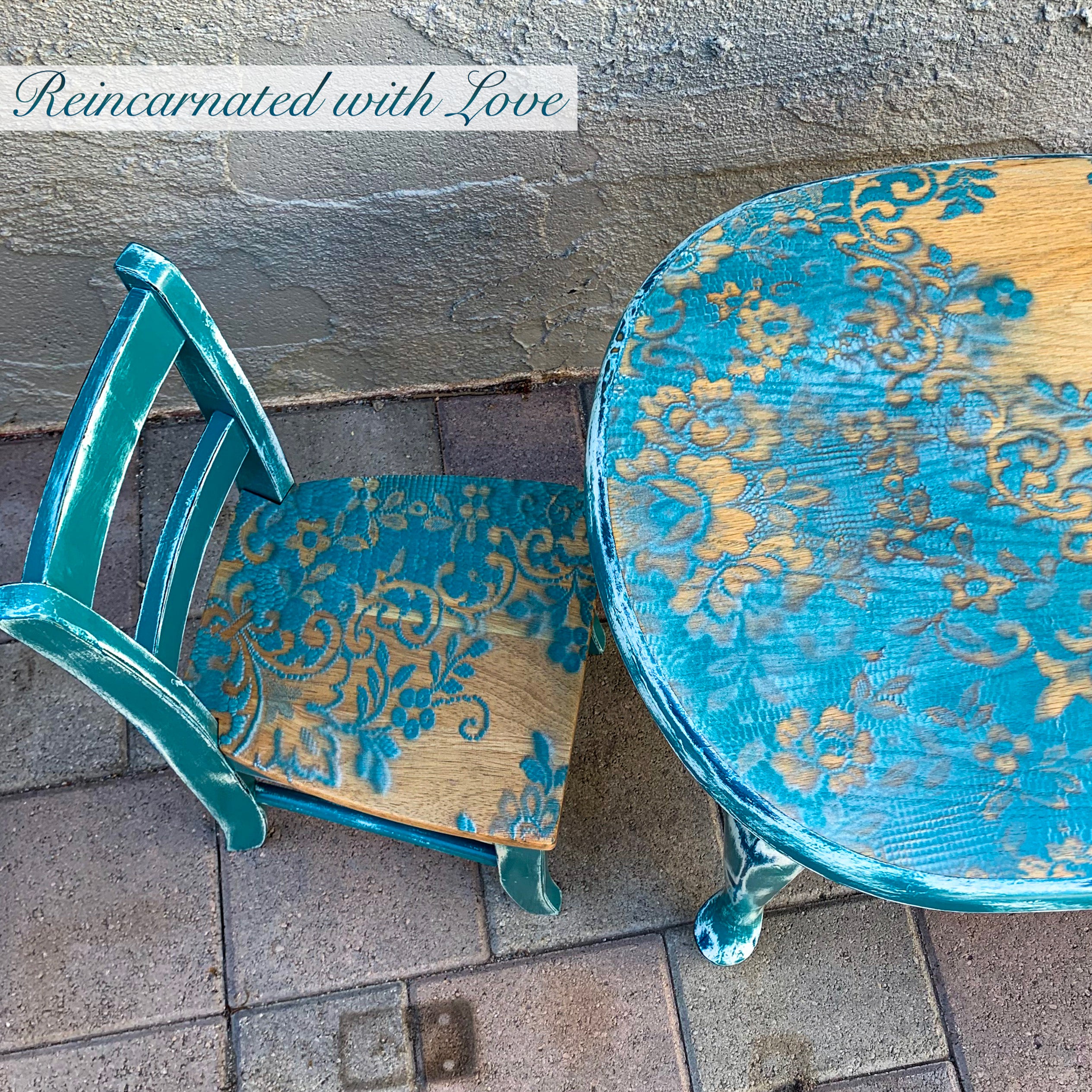 Close up shows blue, lace accents done on the chair seat & stained wood tabletop of the kid’s table.