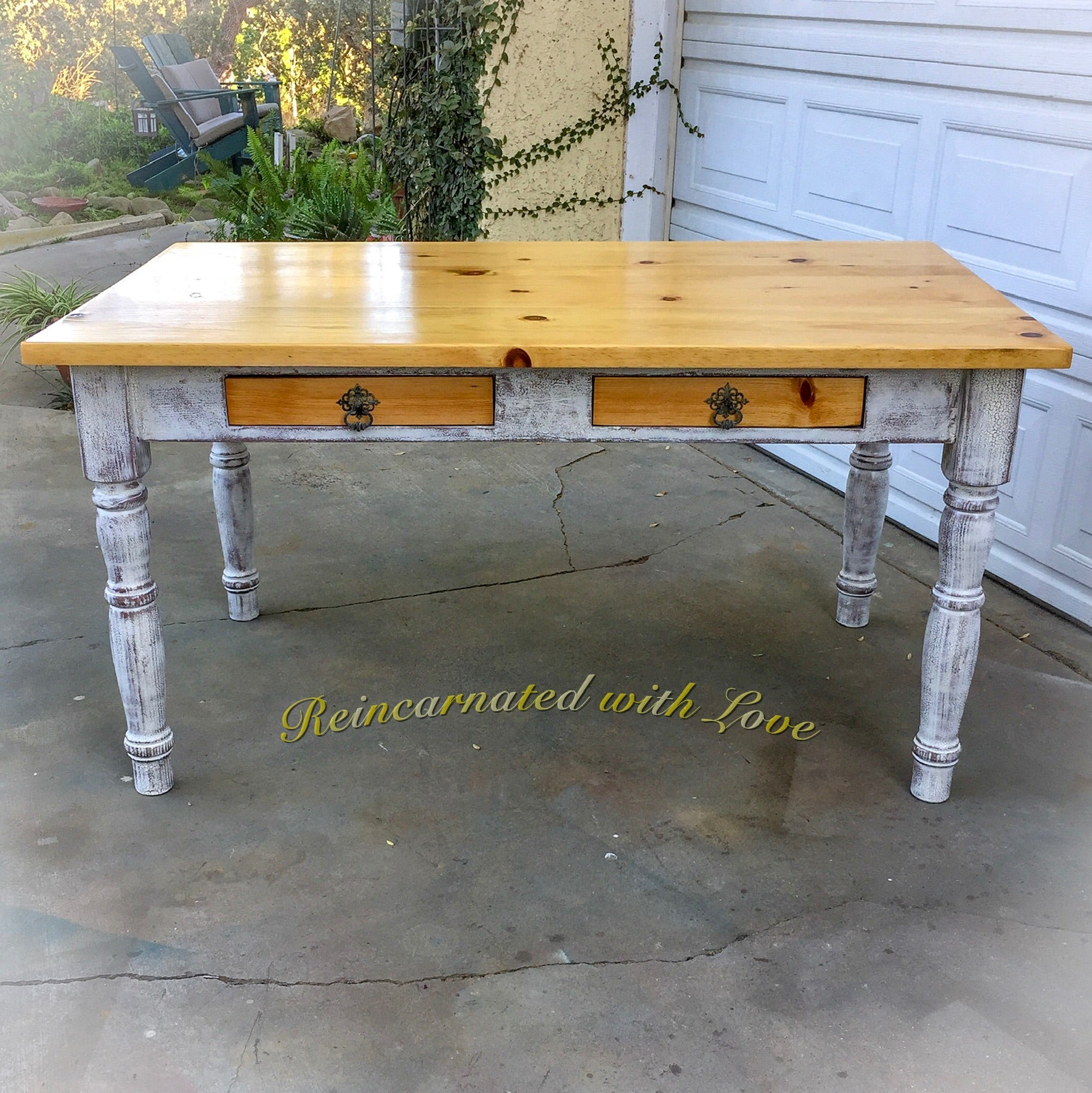 A farmhouse style, kitchen table, with a stained wood tabletop & distressed white base.