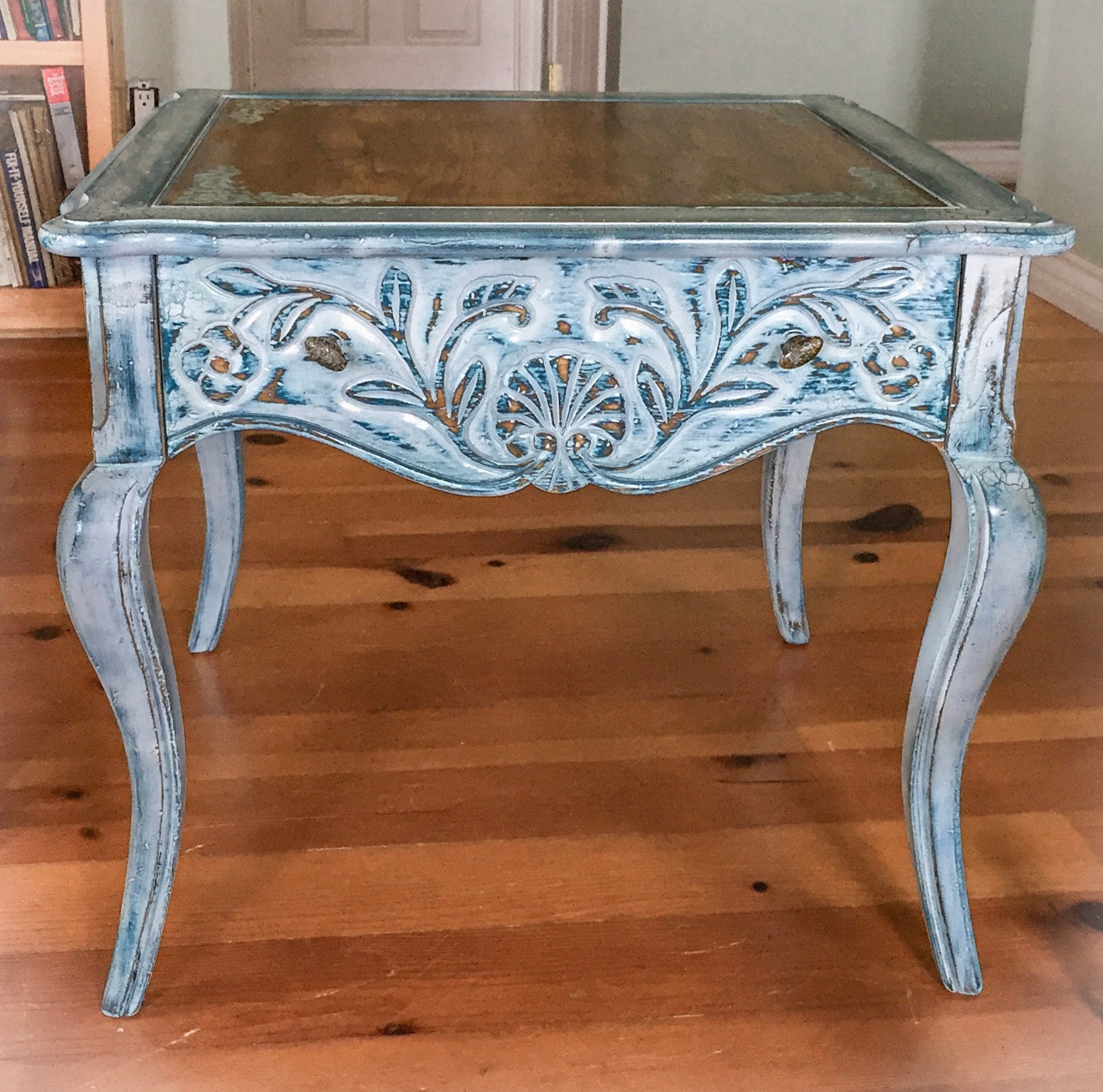 Front view of the side table shows wood carved accents on drawer, patina knobs & curved table legs.