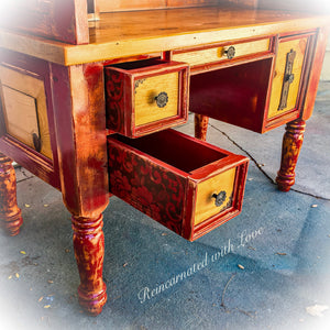 A reclaimed wood desk, painted in distressed red & stained wood, with lace accents on the drawer side panels.