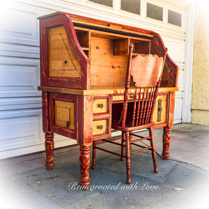 The side view of a farmhouse style, roll top desk & matching chair, painted with red trim over stained wood.