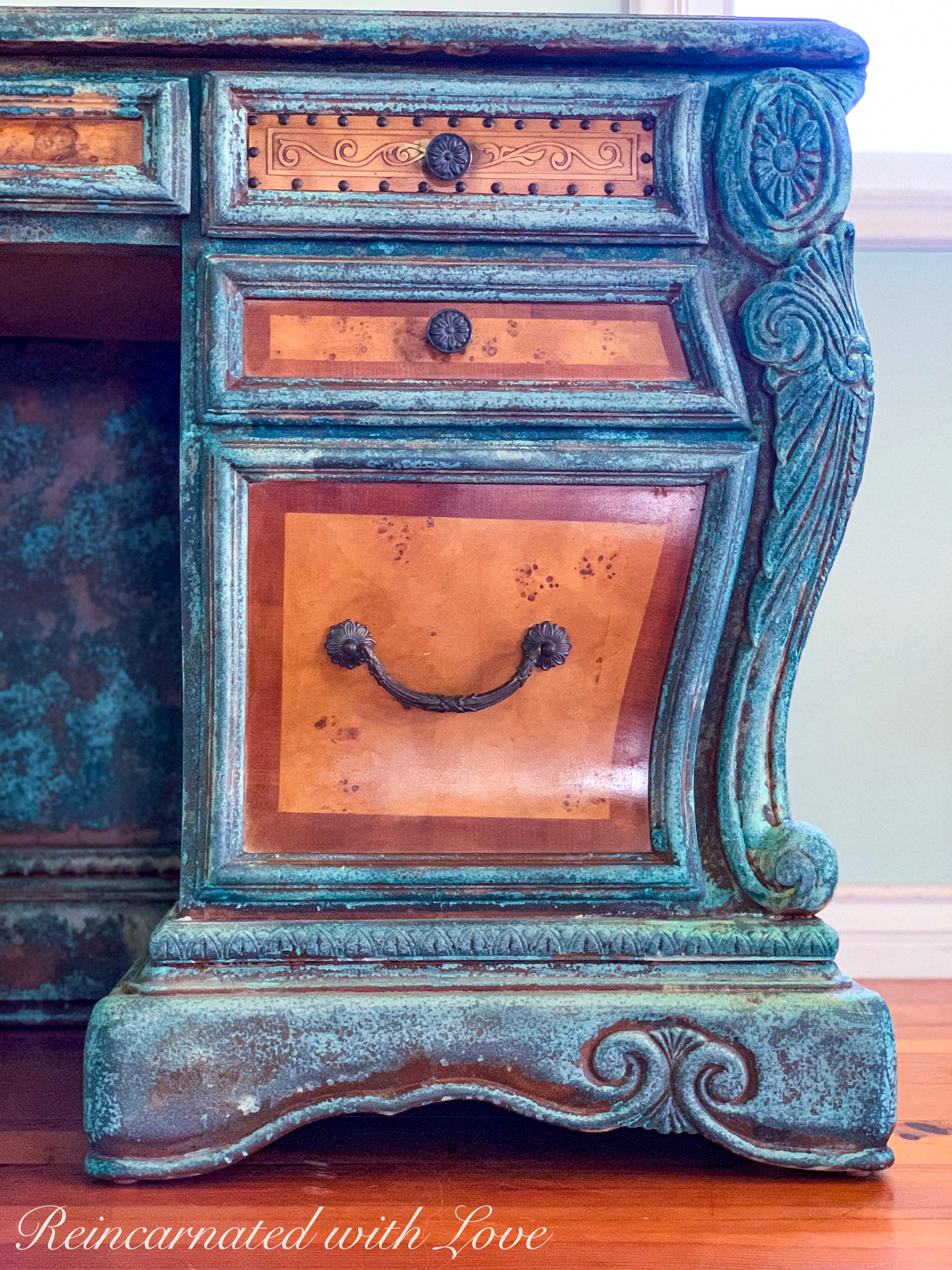 Close up of the drawers on a boho style desk, showing the wood carved accents & details in the blue & green finish.