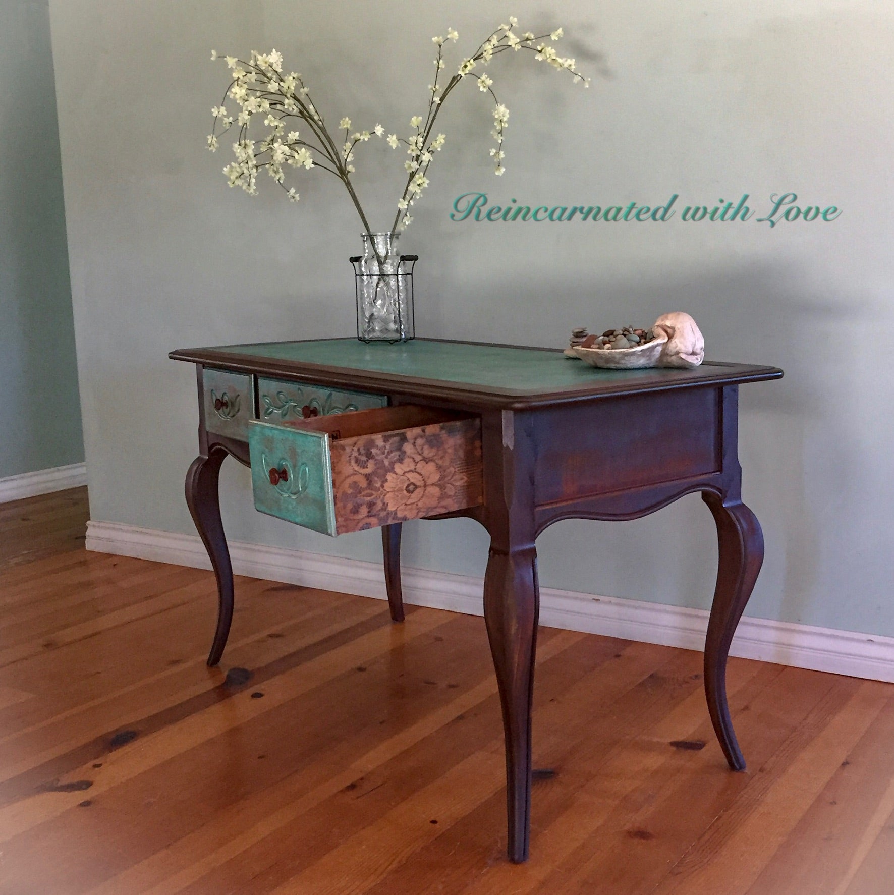 A French country, writing desk with curved legs & three drawers, done in a boho style, rusted iron & green, patina finish.