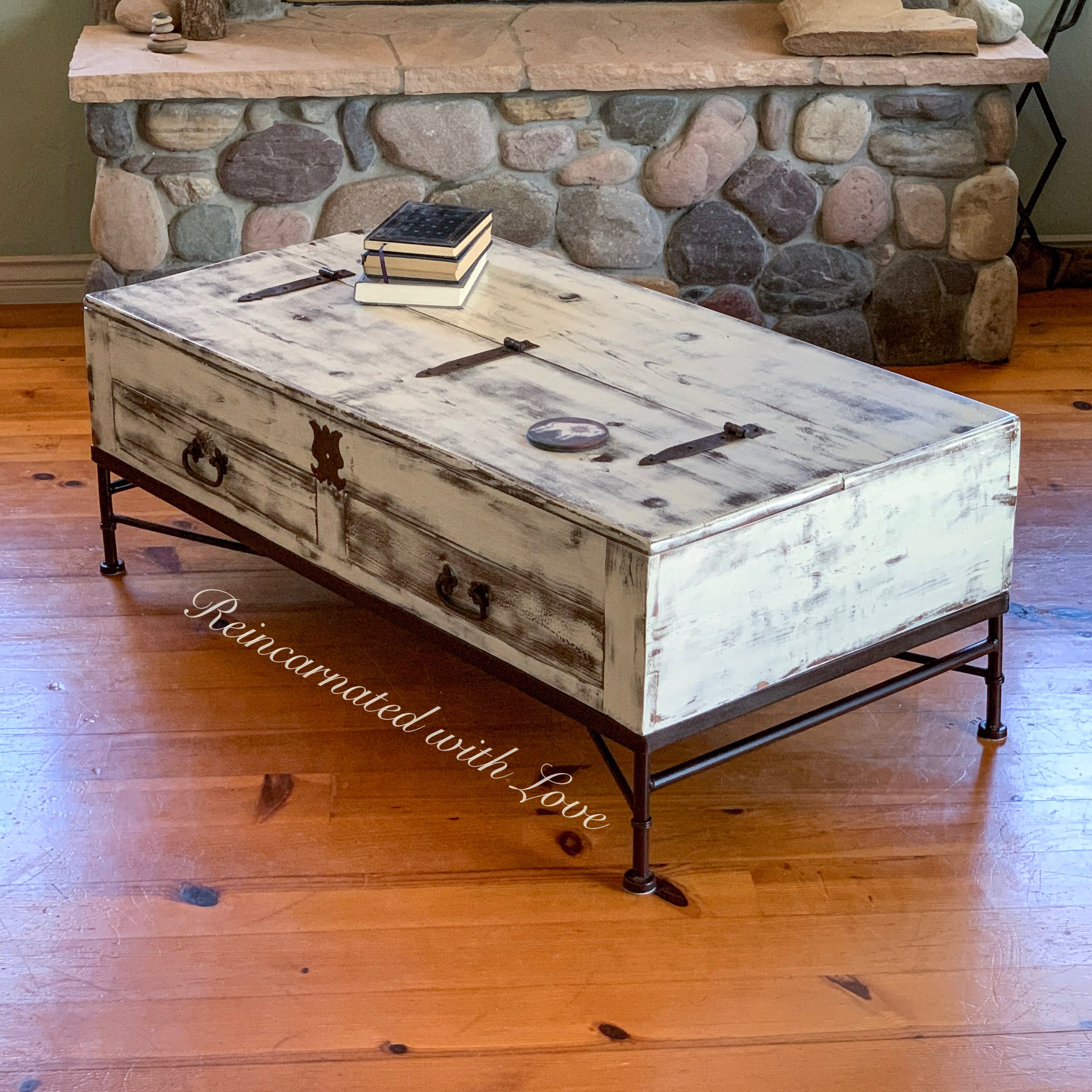 A lift top, coffee table, with a distressed, white finish, wrought iron base & hardware.