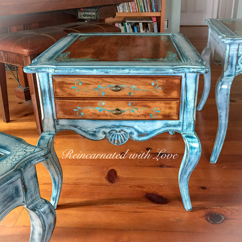 A French country style, end table with a stained wood tabletop, distressed, white trim, blue hues & damask accents.