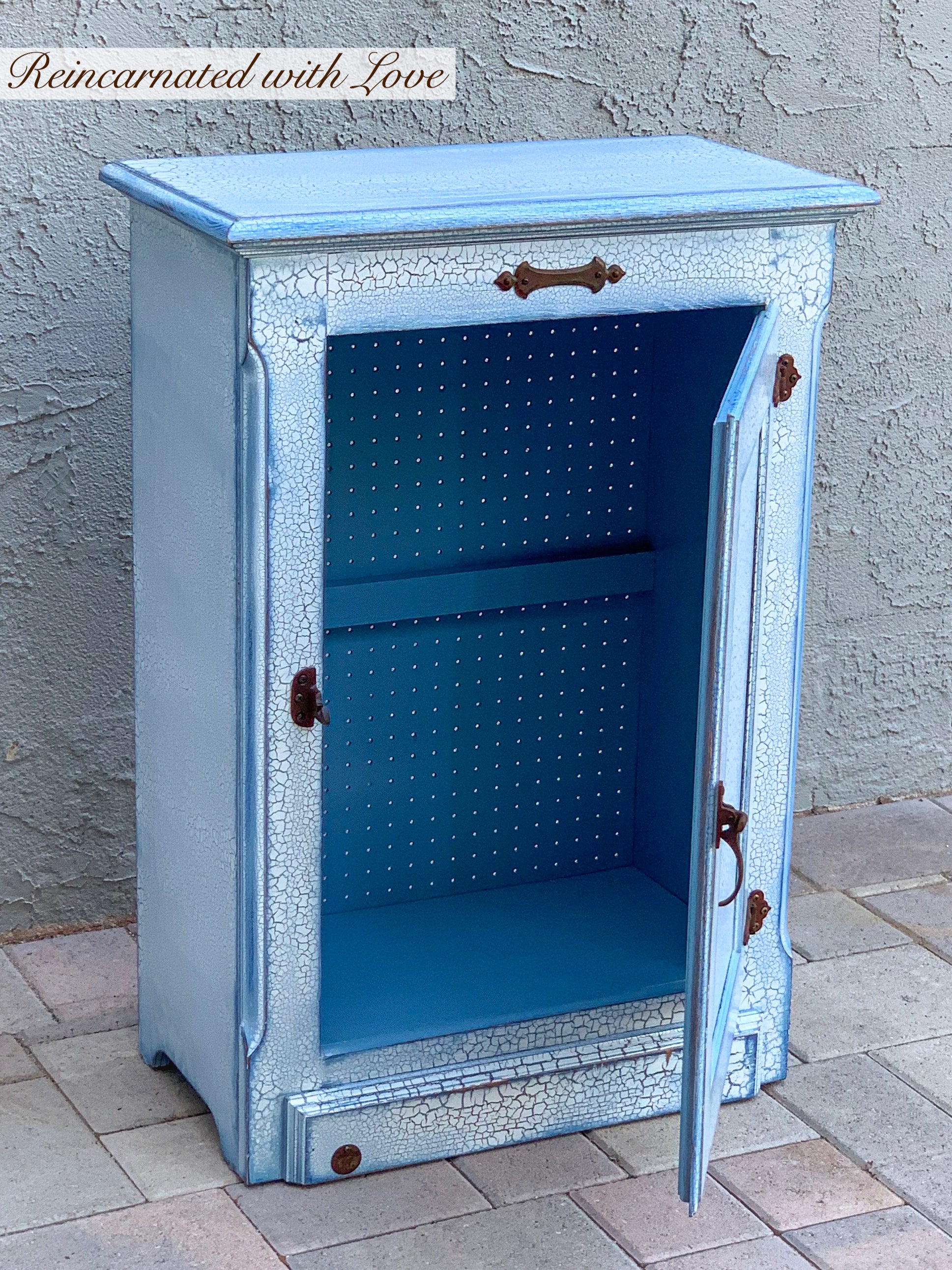 Shabby chic hamper with it’s front, cabinet door open to the large, inside area, painted in blue.