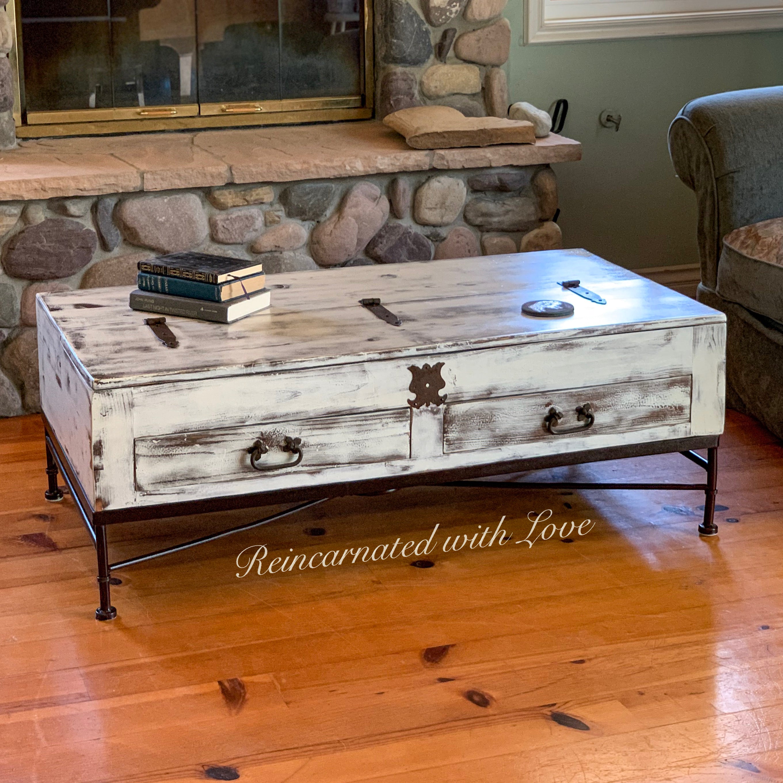 Living room with a reclaimed wood, coffee table, done in distressed white with a wrought iron base.