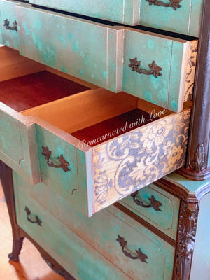 Close up of lace details on the drawer side panel of a boho style dresser, done in a green, patina & rusted, iron finish.