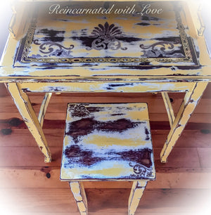 Close up of the tabletop on secretary style desk, painted in a rustic, yellow finish, with damask accents & a matching stool.