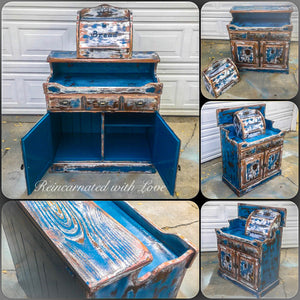 A piece of vintage furniture, repurposed into a farmhouse style, coffee bar, painted with a heavily distressed blue finish.