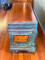 Top view of boho style desk, showing a stained, burl wood, inlaid tabletop with a blue & green, patina finish.