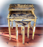 A vintage, secretary style desk, painted in a rustic, yellow finish over stained wood with a matching stool.