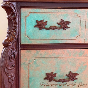 Close up of the green, copper patina & rusted, iron finish on a boho style dresser with floral drawer pulls.