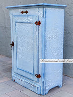 Side view of the shabby chic hamper, shows the iron rusted hinges & outer finish, painted in white, with blue undertones.