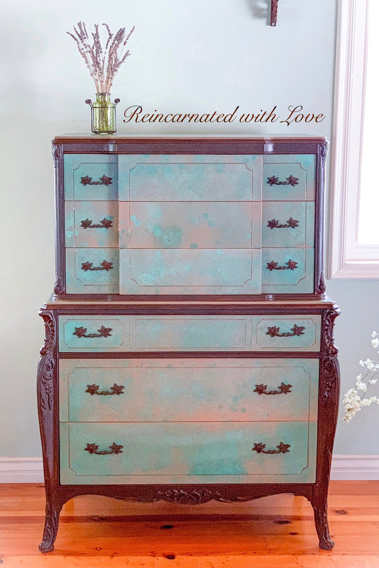 A tall, art-nouveau style, antique dresser, done in a green, patina finish with rusted iron accents.