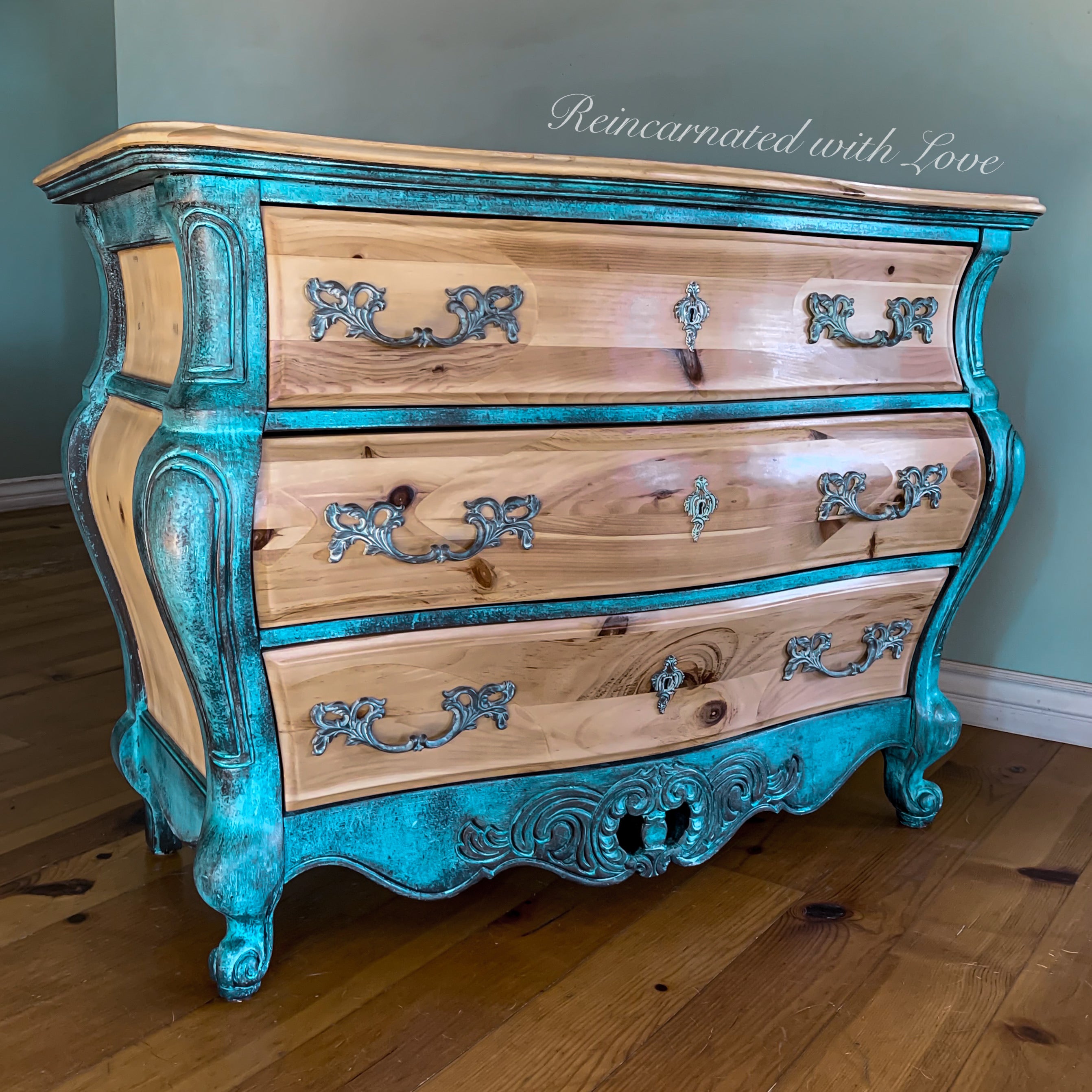 A curvy, boho style dresser done in blue & green patina hues over stained solid pine.