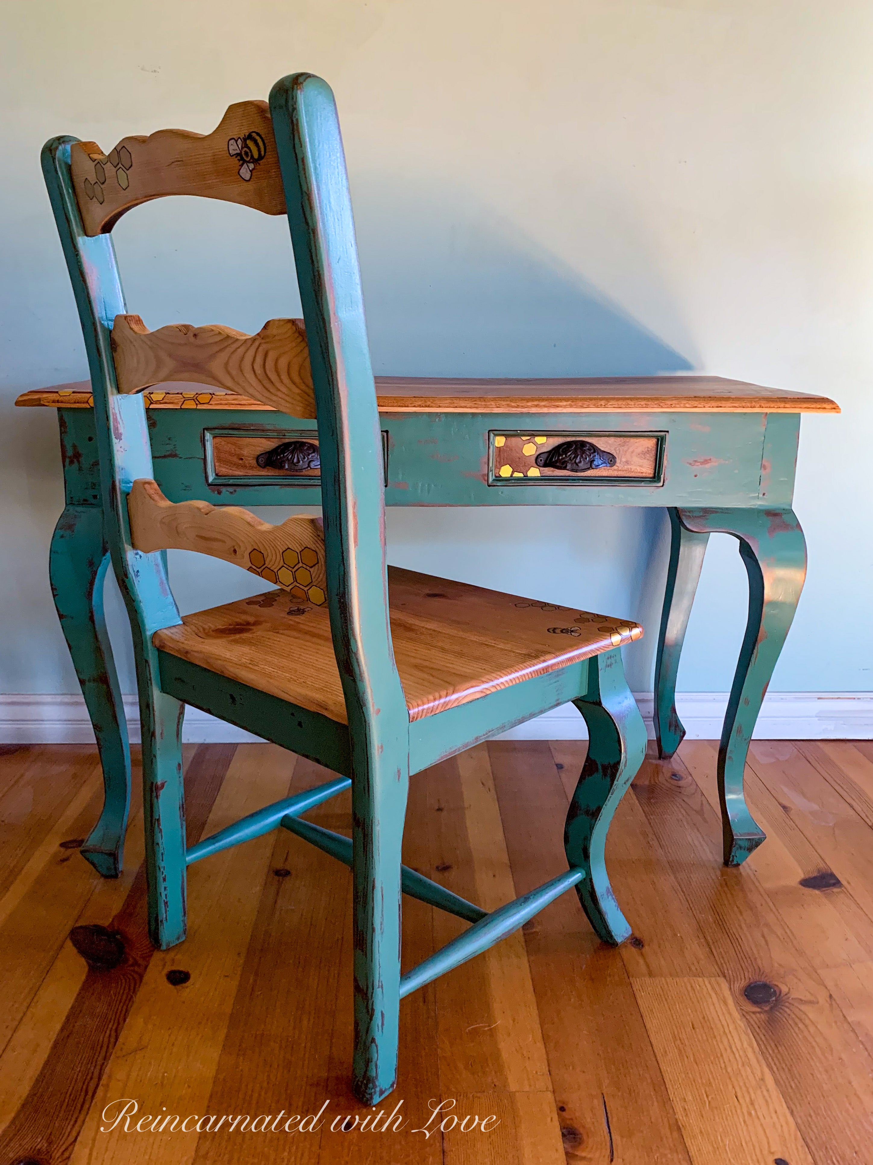 A vintage writing desk & chair set done in stained solid wood, with curved legs & distressed green trim.