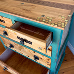 Close up of burnt wood, iridescent honeycomb & tiny bee accents on a vintage chest of drawers.