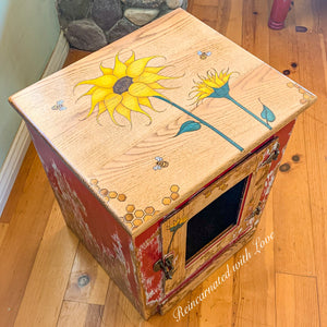 A farmhouse style vintage nightstand painted in distressed red with honeycomb, sunflowers & bees