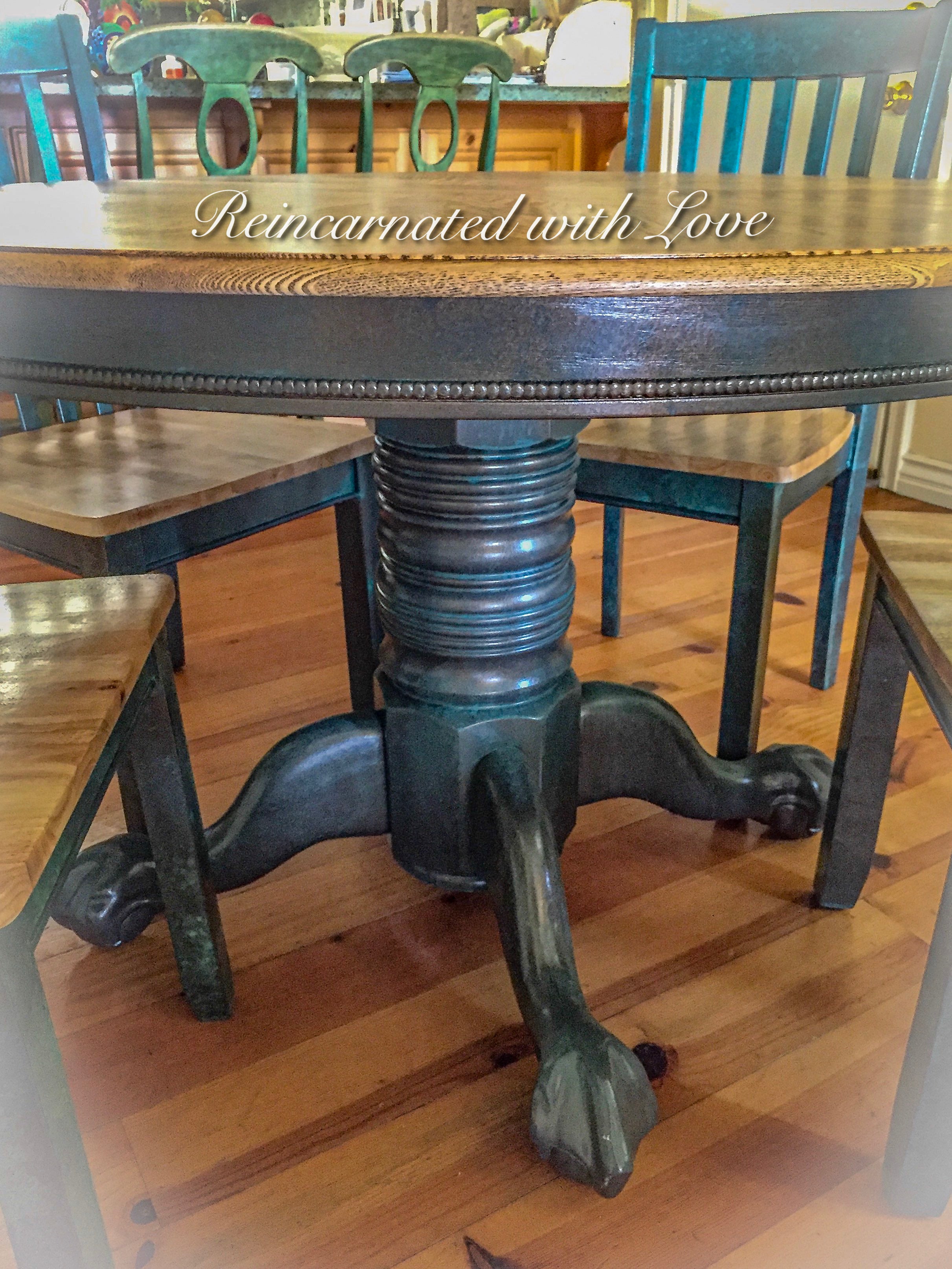Pedestal base on a vintage dining table painted in blue patina with stained wood tabletop.