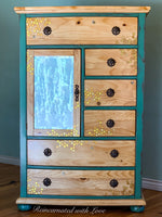 A tall vintage dresser painted in distressed green over stained wood with honeycomb & bee accents.