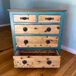 A vintage chest of drawers with iridescent honeycomb & tiny bee accents burnt into the wood grain.