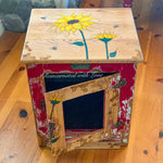 A country style end table in distressed red with sunflower, honeycomb & bee accents.
