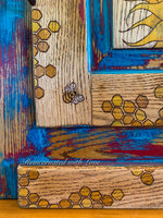 close up of honeycomb & bees on the stained wood portions of a painted vintage nightstand.
