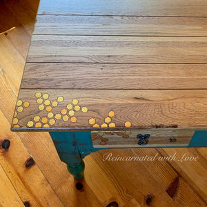 Close up of burnt wood, iridescent honeycomb & tiny bee accents on an oak coffee table.