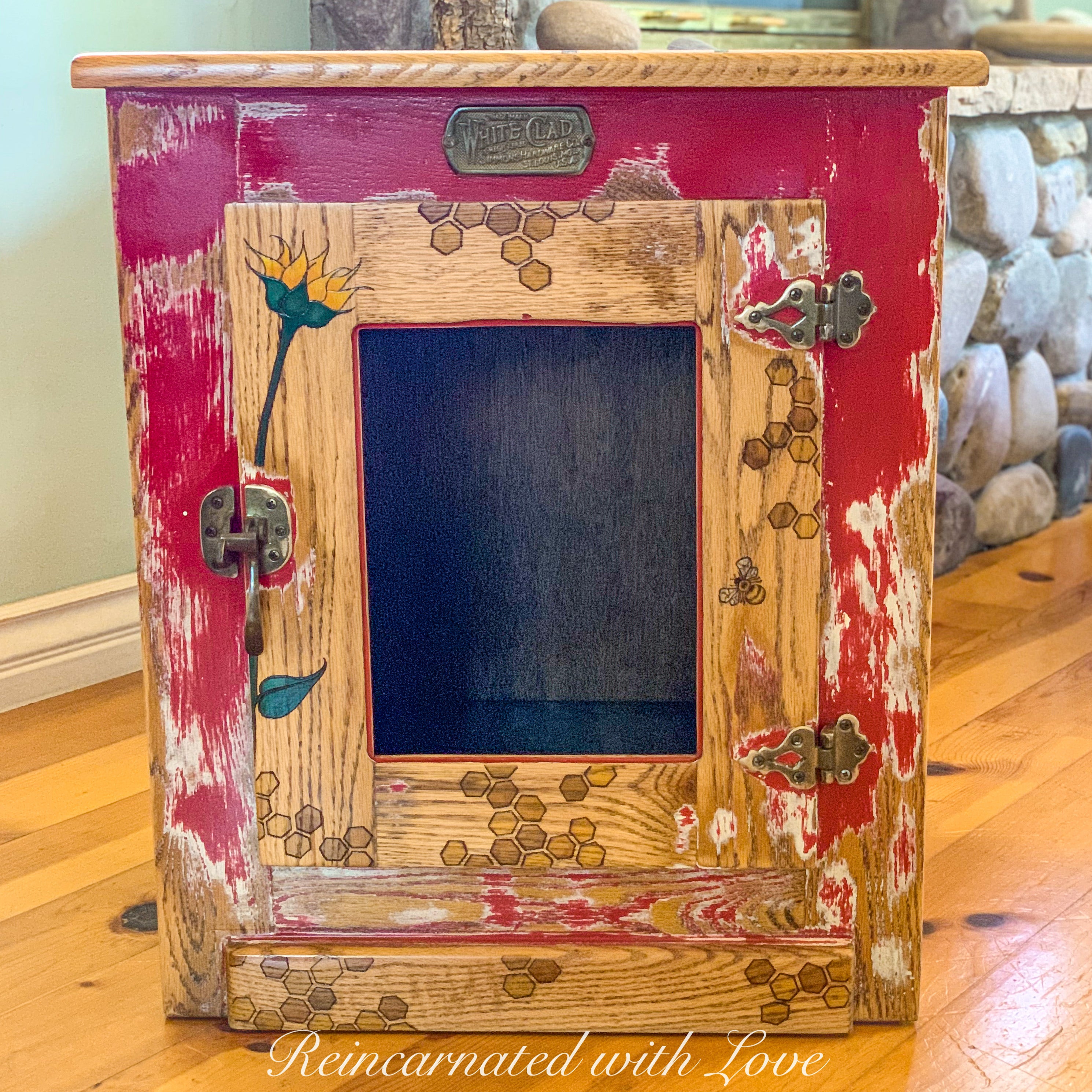 A red farmhouse end table repurposed as a cat cave with honeycomb & bee accents over solid wood.