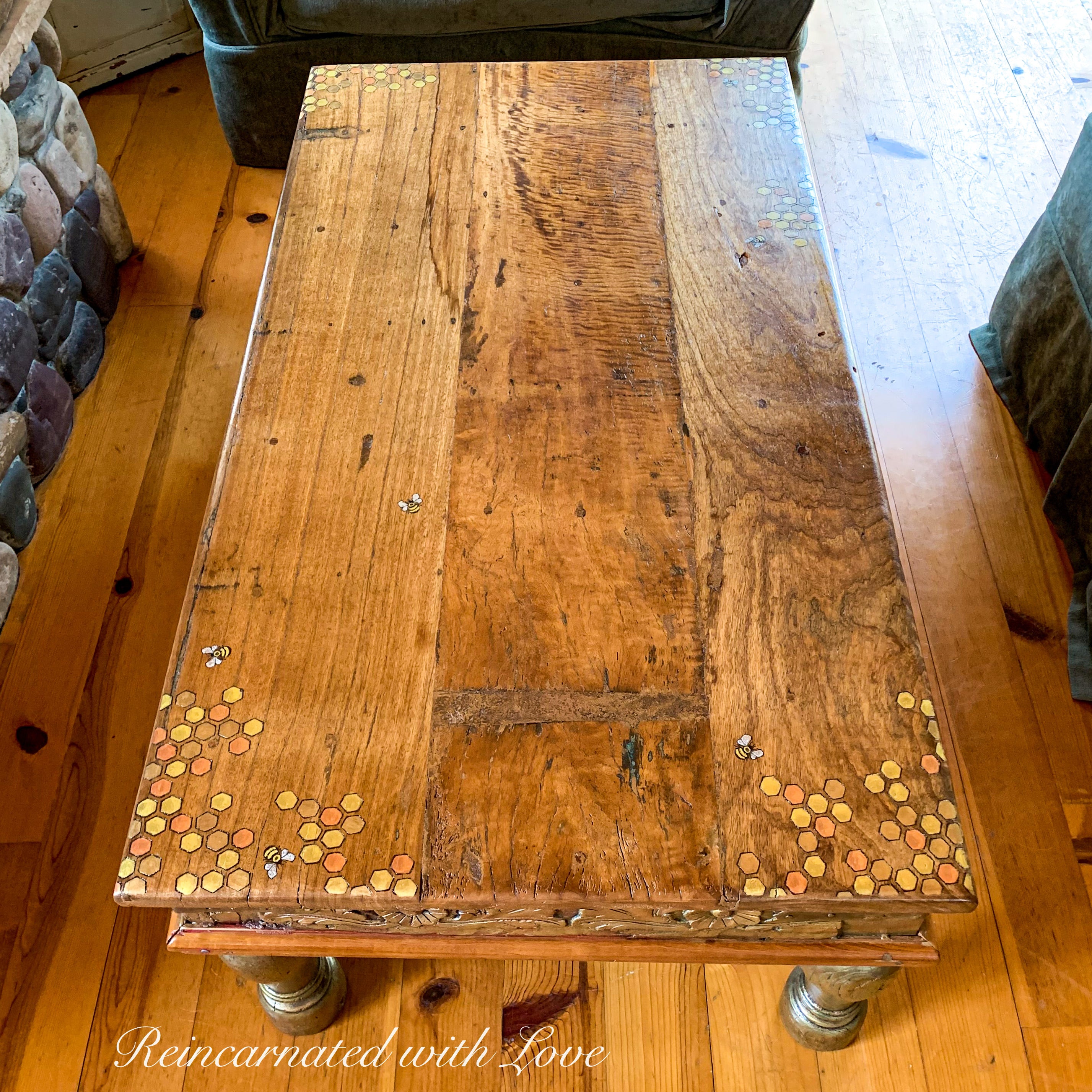 A reclaimed wood coffee tabletop with honeycomb & tiny bee accents burnt into the woodgrain.